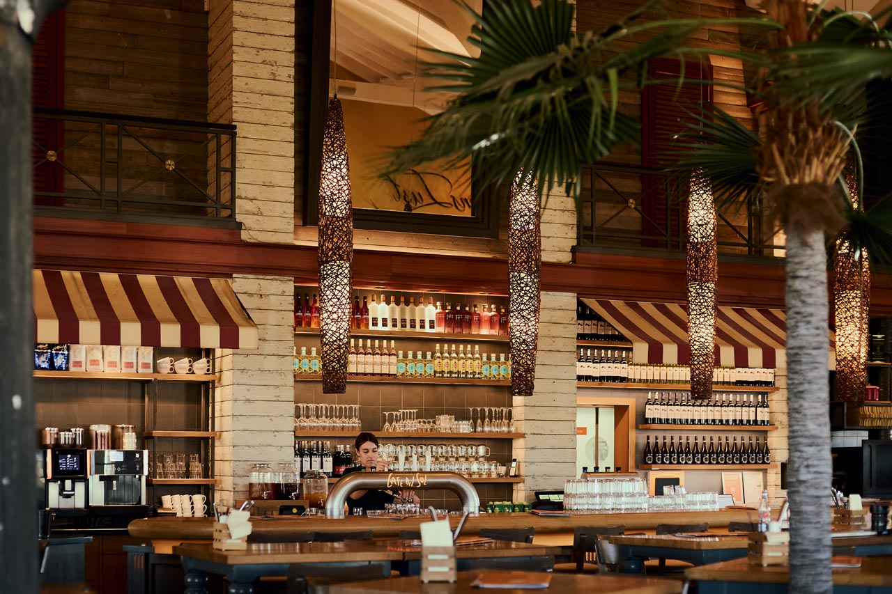 Cafe Del Sol Bar mit Bedienung, Palmen und Getränkewand